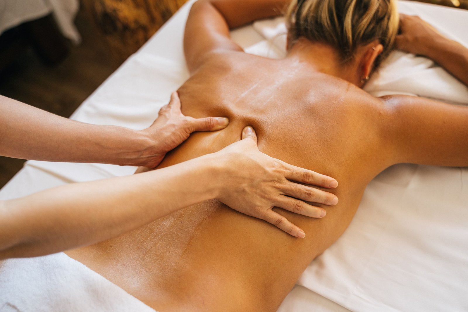 Close-up of a Deep Tissue massage therapy session with focus on back and hands.